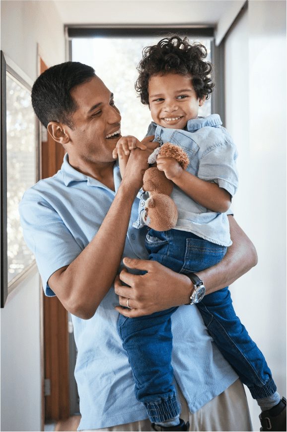 A father lifting his laughing child at home